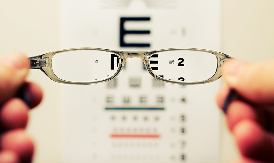 looking through glasses to eye test board